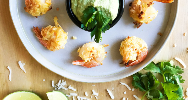 platter of coconut shrimp with green sauce and herbs