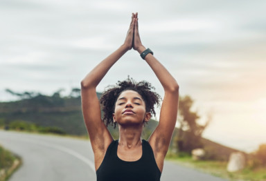 Woman doing yoga outdoors in sun