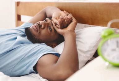 Man in bed suffering from insomnia and sleep disorder