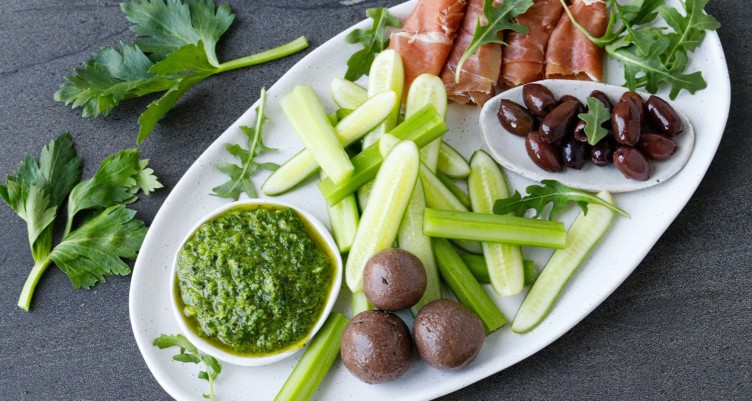 plate with pesto cucumbers meat and olives