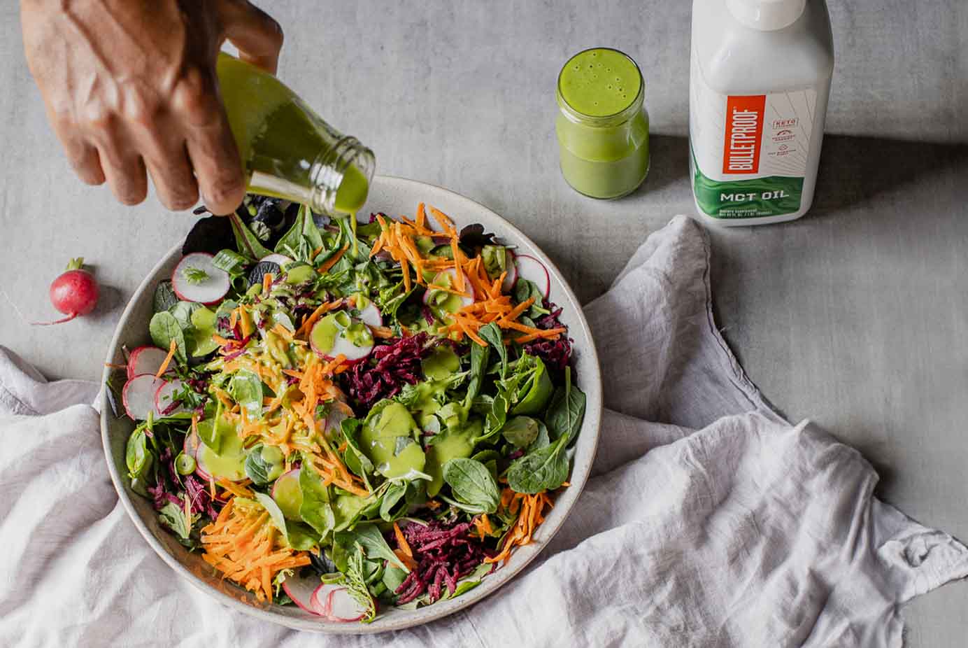 Salad dressing pouring over fresh salad in bowl