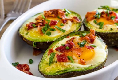 Dish of avocados filled with eggs, bacon & chives