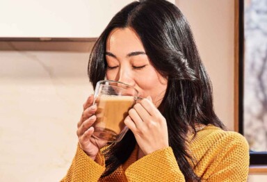 Woman with brown hair drinking a creamy cup of Bulletproof Coffee