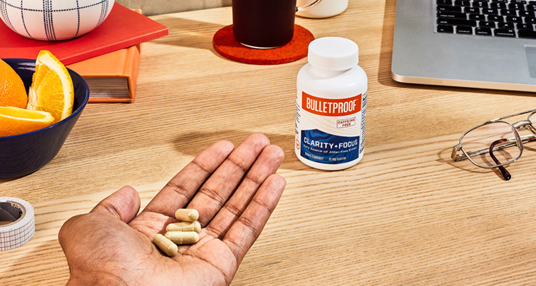 hand of pills next to workspace