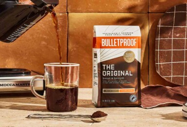 coffee pouring into mug next to a bag of Bulletproof coffee grounds