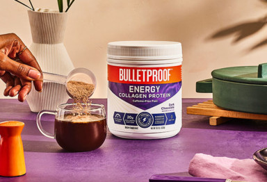 Hand scooping Bulletproof Energy Collagen Protein into coffee mug