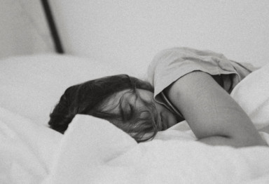 Black and white photo of woman sleeping in bed