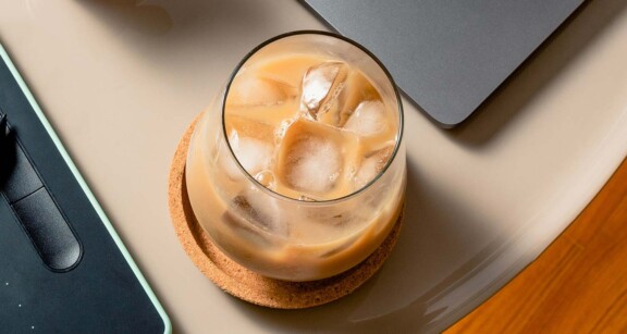 Overhead view of a cup filled with iced Bulletproof coffee on tabletop