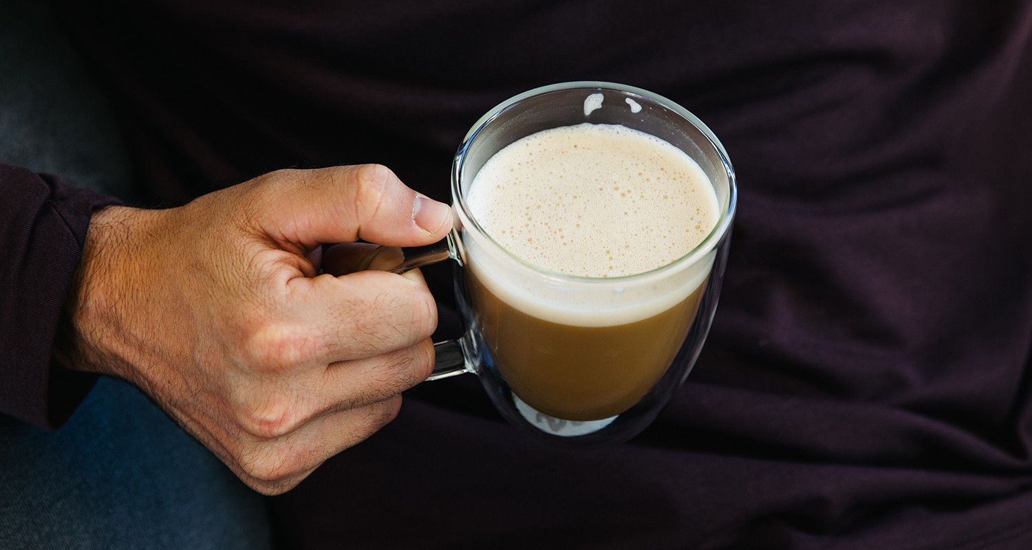 hand holding a cup of mushroom coffee