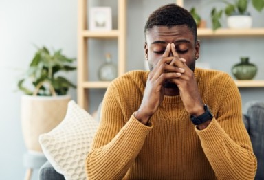 Stressed man in yellow sweater at home