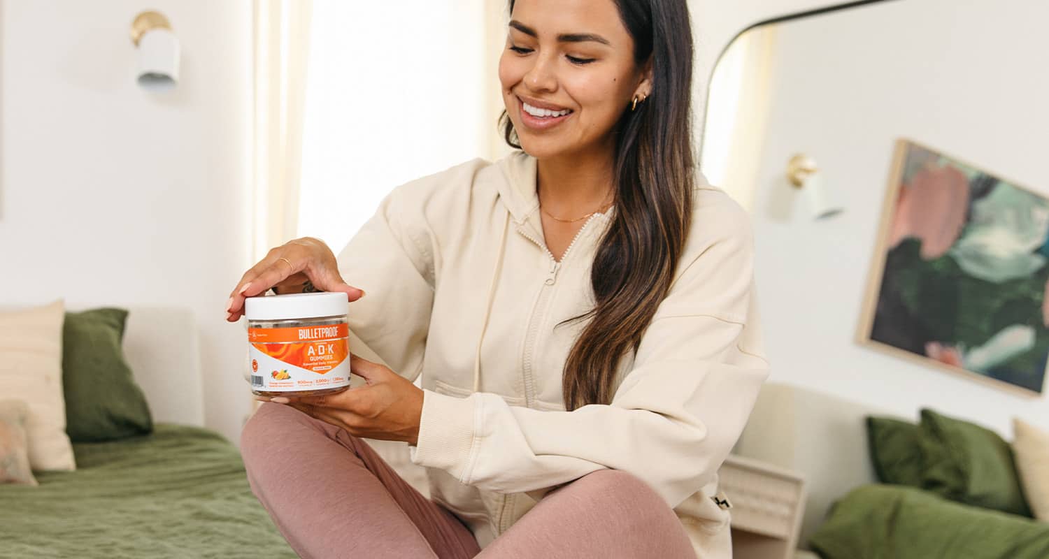 woman opening container of gummy vitamins