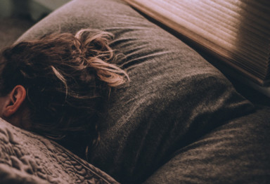 Woman with head on gray pillow