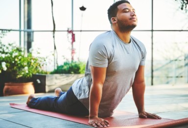 Man practicing upward facing dog yoga pose.