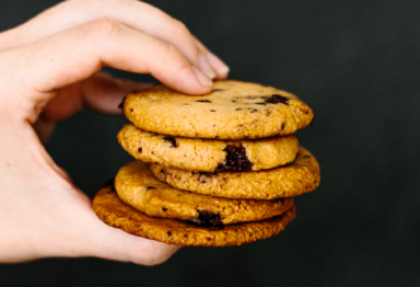 A hand holding a stack of cookies